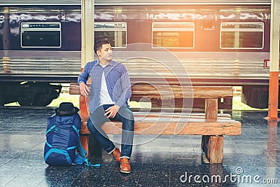 Traveler man waits train on railway platform Stock Photo