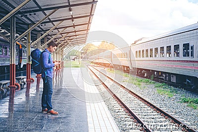 Traveler man waits train on railway platform Stock Photo