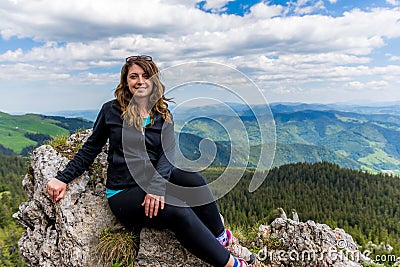 Traveler posing on rocks in the background of Rarau Mountains, Romania Stock Photo
