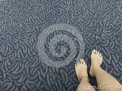 The traveler`s legs which wears ankle bracelet is placed on the chair near by her luggage. Stock Photo