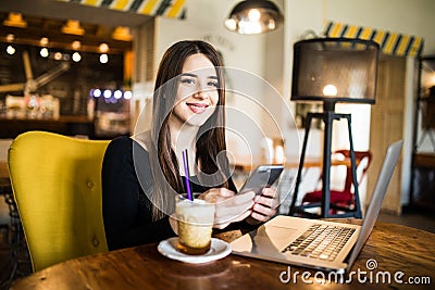 Traveler sending emails with laptop and smartphone during coffee break indoor Stock Photo