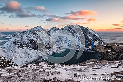 Traveler sitting on Ryten mountain with Kvalvika beach on sunset at Lofoten islands Editorial Stock Photo