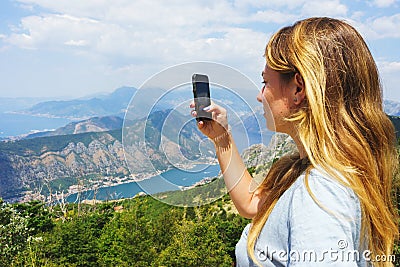 Traveler smartphone, landscape photography. Attractive girl takes story on smartphone while traveling mountains in Montenegro. Stock Photo