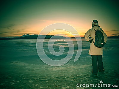 Traveler stay on ice of frozen sea. Woman with backpack Stock Photo