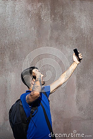 Traveler with tattoos in the arms, lost connectivity and have bad signal in his telephone and hold his sunglasses, search. Stock Photo