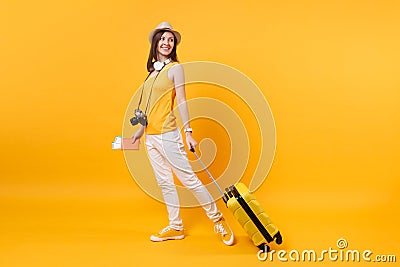 Traveler tourist woman in summer casual clothes, hat with headphones on neck isolated on yellow orange background Stock Photo