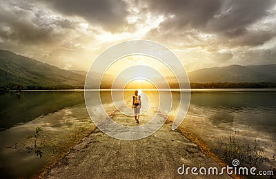 Traveler walking along the road to the mountains Stock Photo