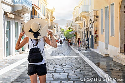 A traveler woman with hat enjoys the picturesque town of Andros, Cyclades, Greece Stock Photo