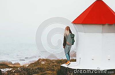 Traveler woman and lighthouse at foggy sea Stock Photo