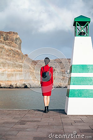 Traveler woman near lighthouse enjoy mountain and ocean Stock Photo