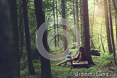 Traveler woman rests in a mysterious and surreal forest Stock Photo