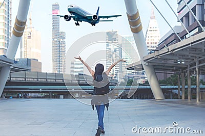 Traveler women plan and backpack see the airplane at the airport in the modern city. Asian freedom and relax on the park city. Stock Photo