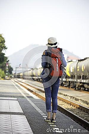 Traveler women walking alone Carrying luggage and waits train Stock Photo