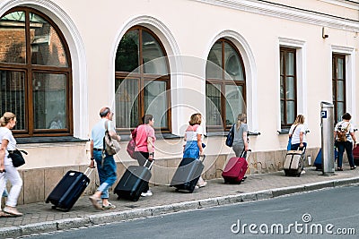 Travelers carrying suitcases at old town street in Krakow, Poland Editorial Stock Photo