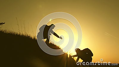 Travelers climb the cliff holding hand. teamwork of business people. Happy family on vacation. traveler man extends his Stock Photo