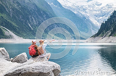 Travelers couple look at the mountain lake. Adventure and travel in the mountains region in the Austria Stock Photo