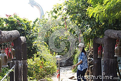 Travelers thai women travel visit and rite ritual knock metal bell for respect pray god angel buddha at Wat Roi Phra Phutthabat Stock Photo