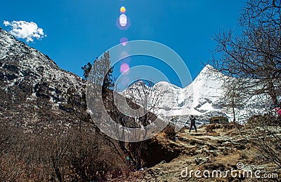 Travelers walking on walkway with snow-capped mountains to Milk Lake in Yading Nature Reserve, Sichuan, China Editorial Stock Photo