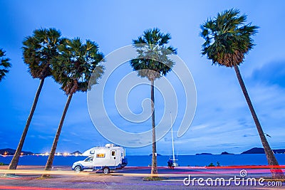 Traveling by campervan or motorhome on road along the sea at sun Stock Photo