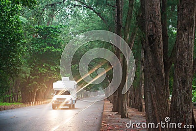 Traveling in a campervan on the pine road at dusk Stock Photo
