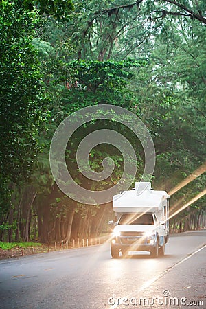 Traveling in a campervan on the pine road at dusk Stock Photo