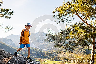 Traveling child. tourist with a backpack goes along a mountain path. hiking and active healthy lifestyle Stock Photo