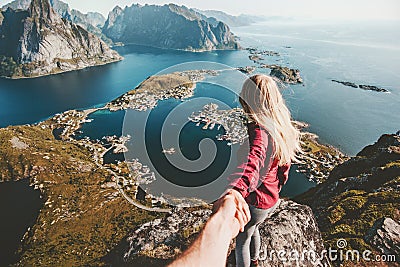 Traveling Couple follow holding hands on cliff mountain Stock Photo