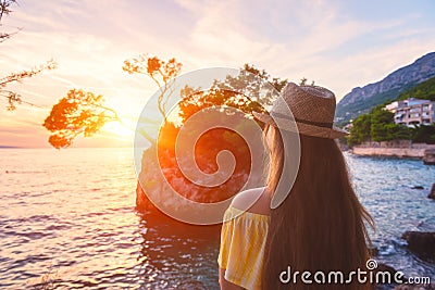 Traveling girl enjoys amazing sunset view and Brela stone and Adriatic seacoast. Travel background, Croatia Editorial Stock Photo