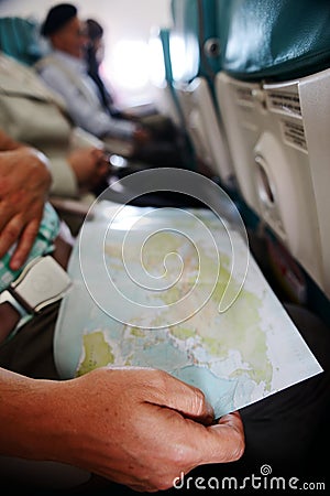 Traveling and looking at the map inside airplane Stock Photo