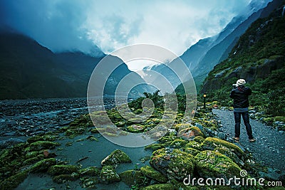 Traveling man take a photograph in franz josef glacier important traveler destination in south island new zealand Stock Photo