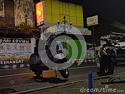 traveling at night on a Vespa looking for a place to brew coffee, and hanging out with friends with very happy hearts Editorial Stock Photo