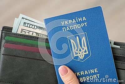 Traveling passport of Ukraine citizen and wallet with dollars in female hands, close up Stock Photo