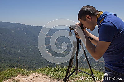 Traveller looking the nature from the high mountain with spotting scope, binoculars tripod Stock Photo