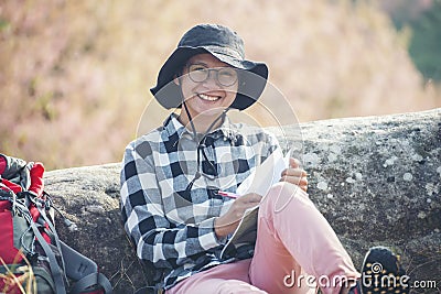 Traveller make note holiday trip on notebook. Asian Woman write and plan daily appointment schedule in diary. Planner mark and Stock Photo