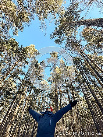 Traveller man in a blue winter jacket ad red cap in the woods. Sandy bay, Baikal lake Stock Photo