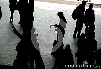 Travellers silhouetted on station concourse Stock Photo