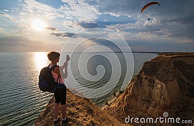 Travelling woman admire to sunset Stanislav clay mountains above Dnipro river bay, Ukraine Stock Photo