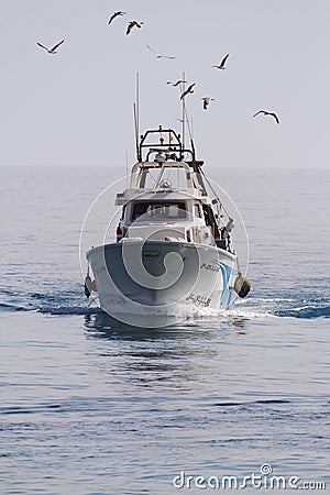 Trawler fishing boat approaching to port. Editorial Stock Photo