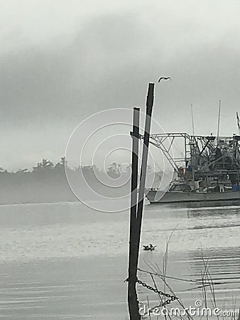 Trawling boat docked in Plaquemines Parish Louisiana on a foggy morning. Stock Photo
