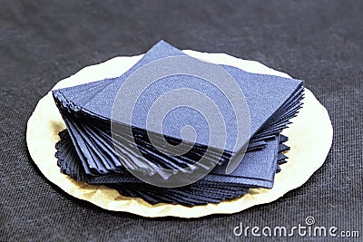 Tray with blue paper napkins elegantly arranged on a dark tablecloth Stock Photo