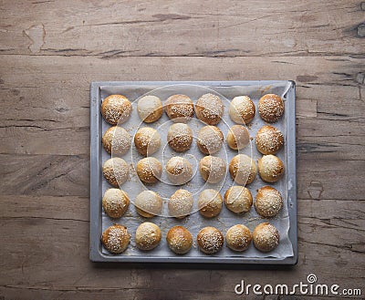 A tray of frech baked buns on a wooden table Stock Photo