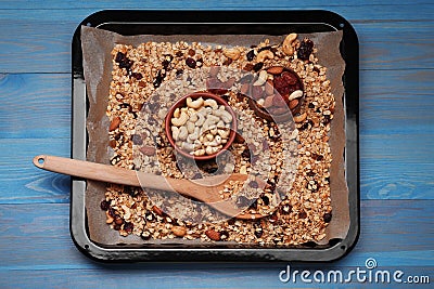 Tray with tasty granola, nuts and dry fruits on blue wooden table, top view Stock Photo