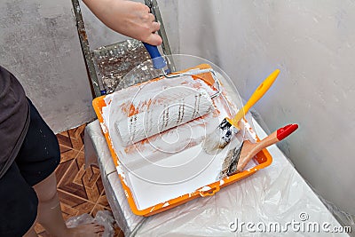 Tray with white paint and painting tools, roller and brushes. Stock Photo