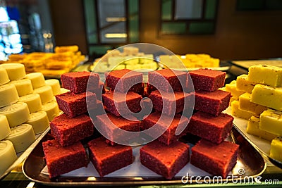 Trays full of stack colorful red velvet Indian sweet dessert in bakery showcase Stock Photo