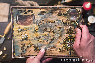 Treasure map in adventurer treasure hunter hands. Stock Photo