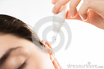 Treatment of ear diseases. A woman buries drops in her ear, close-up. on a white background. Copy space. The Stock Photo