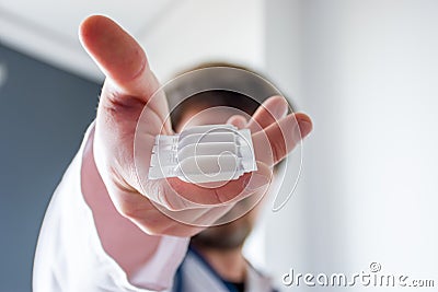 Treatment with medication in form of suppositories concept photo. Doctor holding in his outstretched hand packaging of suppositor Stock Photo