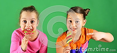 Treatment and sweets concept. Children eat big colorful sweet caramels. Stock Photo