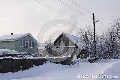 Tree and house in snow in countryside Stock Photo