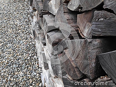 Tree trunks stacked and gravel background - shades of grey Stock Photo